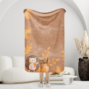 Manta mullida con erizo y cartel de otoño en fondo marrón, hojas y espigas